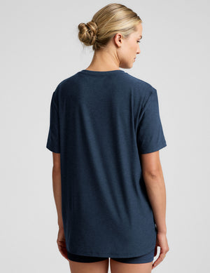 model wearing a blue oversized men's t-shirt and biker shorts against a plain background. 