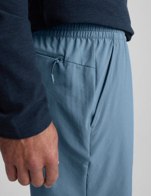 Blue shorts worn by a person on a light gray background. 