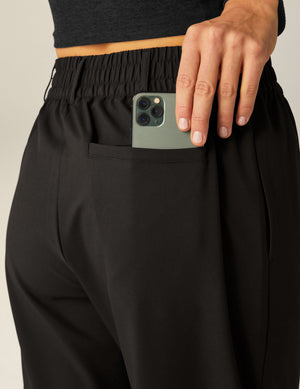 Back view of black Status Wide Leg Trousers featuring an elastic waistband with belt loops and a functional back welt pocket.
