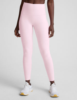 Person wearing pink leggings on a light gray background