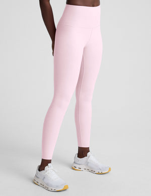 Person wearing pink leggings on a light gray background