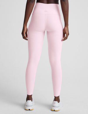 Person wearing pink leggings on a light gray background