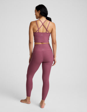Person wearing a mauve athletic outfit on a white background. 